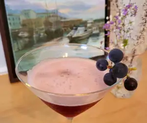 A delicious cocktail with a berry garnish. 
