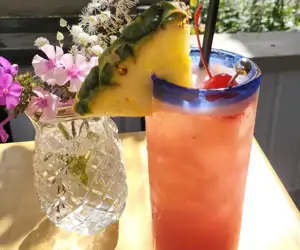 A festive cocktail with a pineapple garnish. 